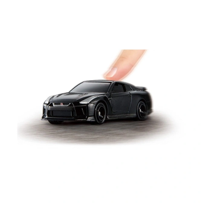 Black toy Nissan GT-R with a finger pressing down on the roof.