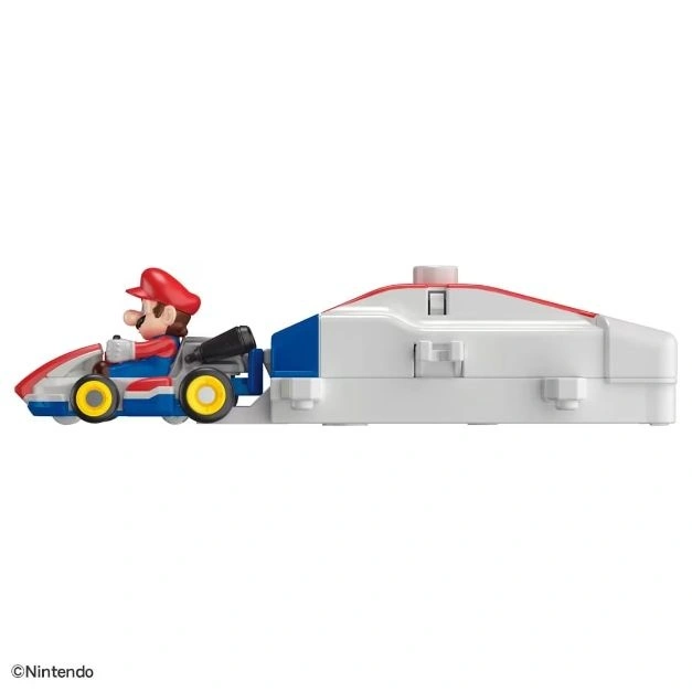  Mario in a toy go-kart with a white trailer attached, ready for racing fun.