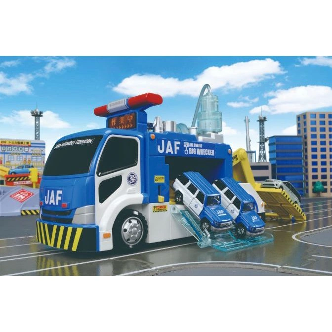 Blue JAF tow truck toy with 3 mini cars on ramp. Yellow crane arm extended. Toy city background.