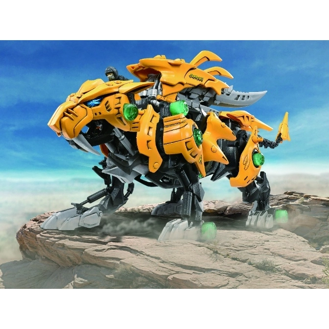  Yellow Zoids Saber Tiger toy with pilot figure on a rocky surface against a blue sky.
