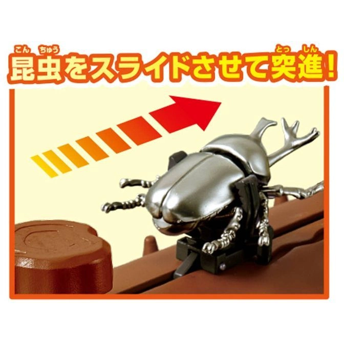  Toy beetle with slide action, ready to charge forward on a brown track. Arrow indicates movement.