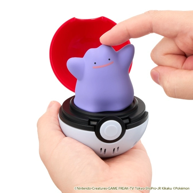  Ditto toy in a Poké Ball being touched by a finger, with the ball's lid open.