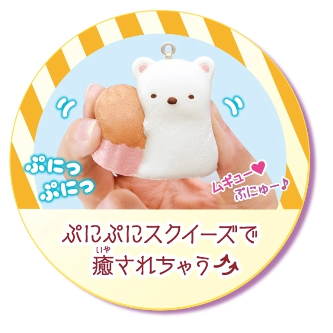  Polar bear squishy toy being squeezed, with a pastry attached. Yellow and white striped background.