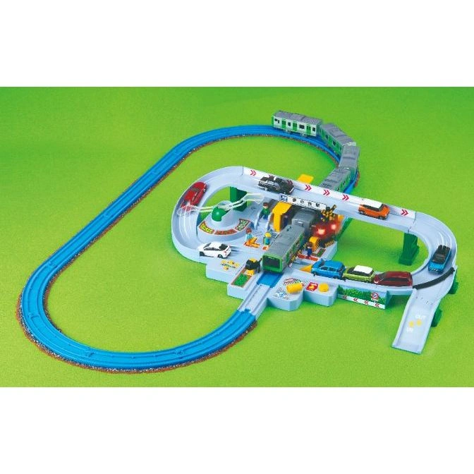 Toy train set with cars, tracks, and a train. The train is on the tracks, and the cars are on the road.