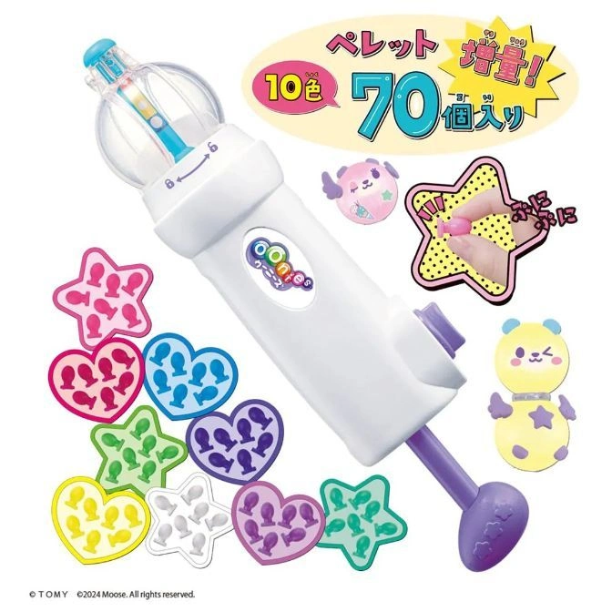 Oonies maker with colorful pellets in star and heart molds. The toy has a white body and purple accents.