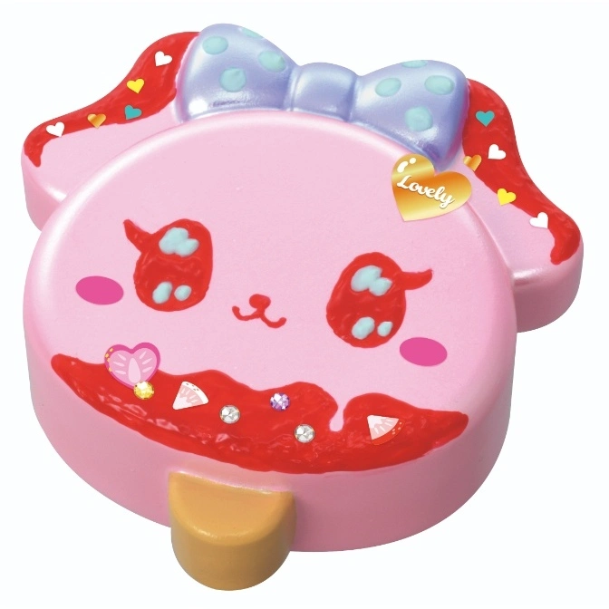 Pink bunny squishy toy with a blue polka dot bow and red frosting-like details.
