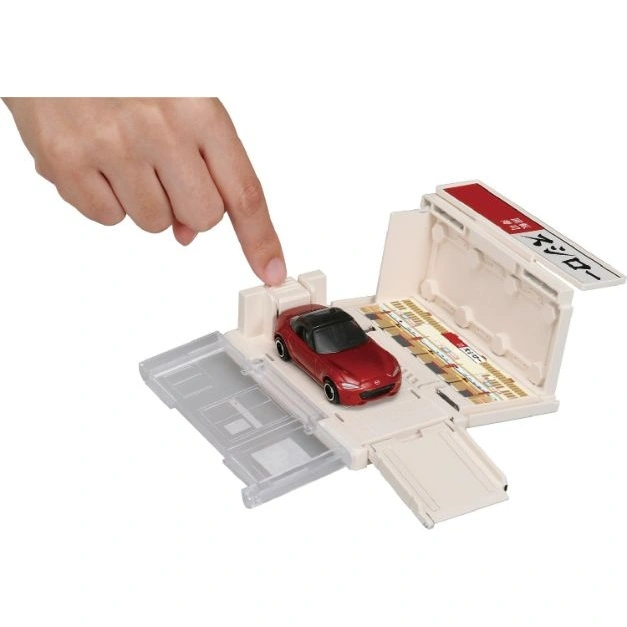  Toy car garage with red Mazda Miata. A finger presses a button.