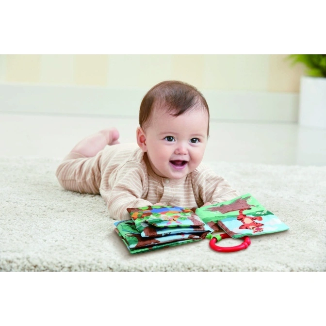  Baby lying on tummy with a Winnie the Pooh soft book toy.