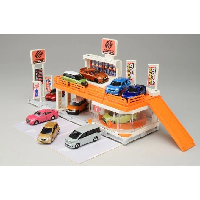 Toy car playset with multiple levels, cars, ramps, and Autobac signs.