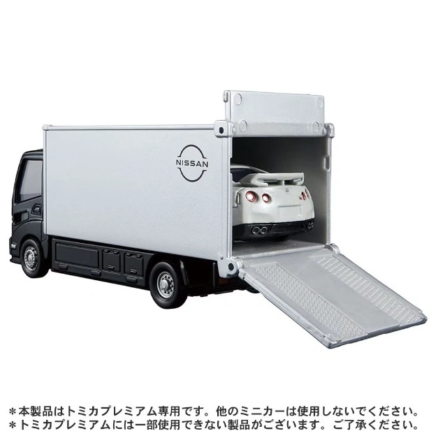  Nissan truck toy carrying a white sports car with its ramp extended.