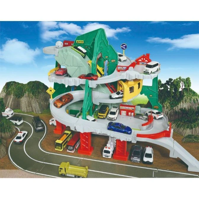 Toy car mountain garage with winding ramps, various vehicles, and miniature buildings.