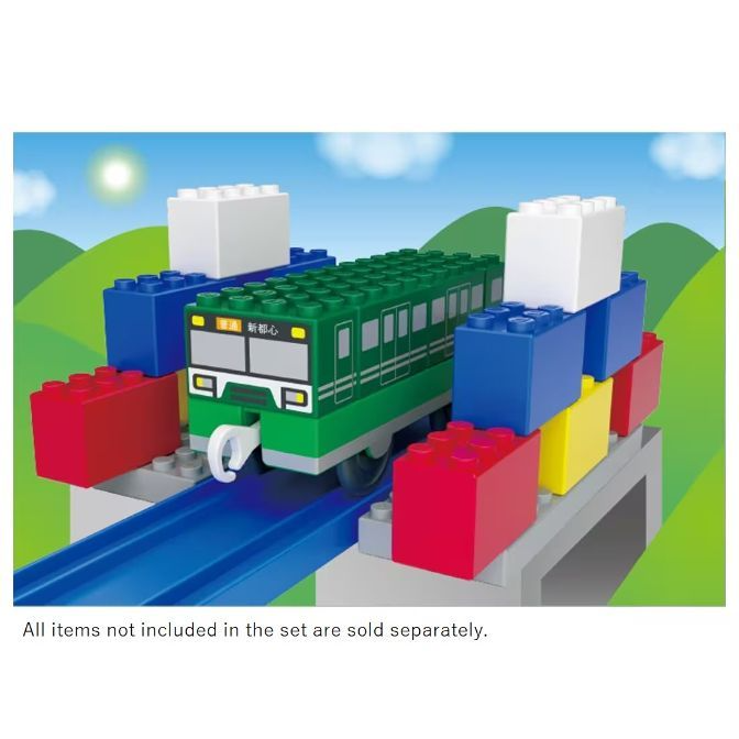  Toy train on a track, built with colorful blocks, against a sky and hill backdrop.