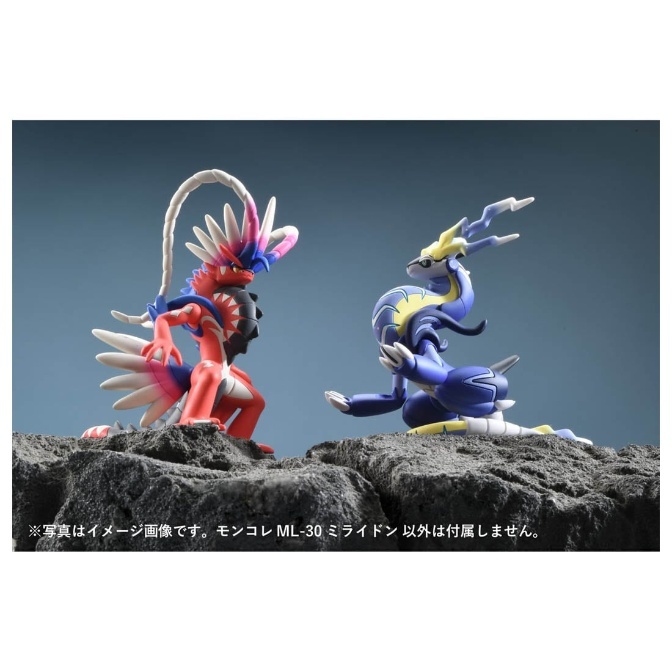 Koraidon and Miraidon Pokémon figures facing each other on a rocky surface.