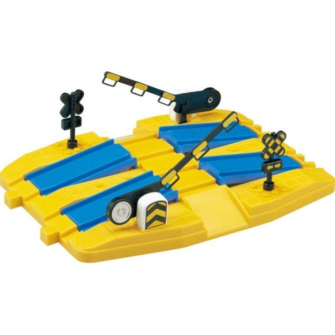 A toy train track crossing with a gate and signs.