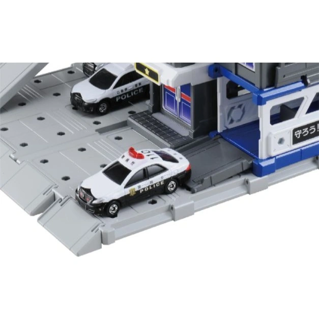  Toy police station with two toy police cars, one with red lights on top.