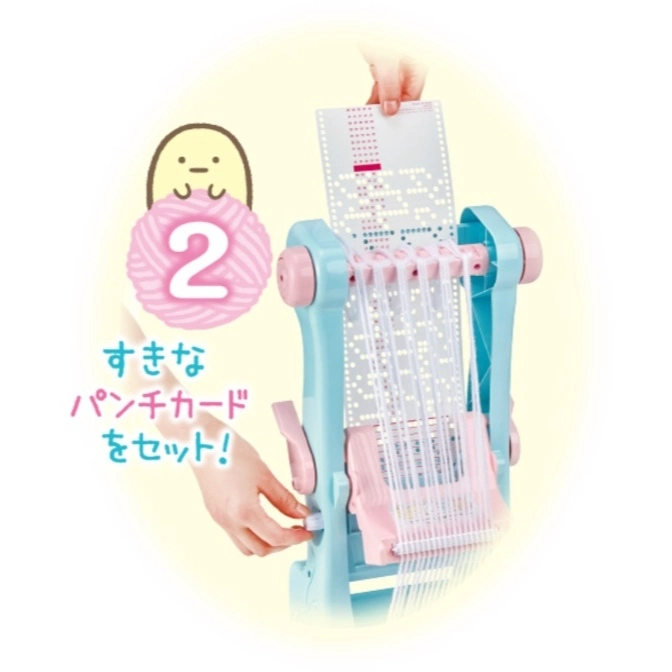  Toy loom with punch card being inserted. Features cartoon character and number 2 graphic.