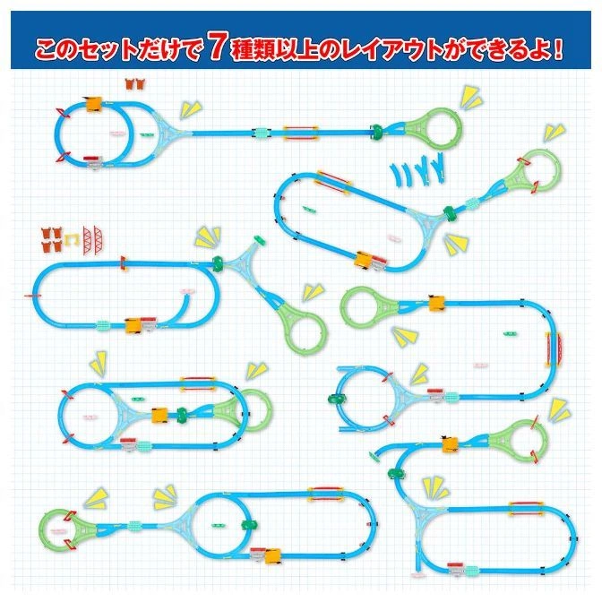  Toy train set with multiple track layouts, featuring blue tracks, green connectors, and yellow trains on a grid background.