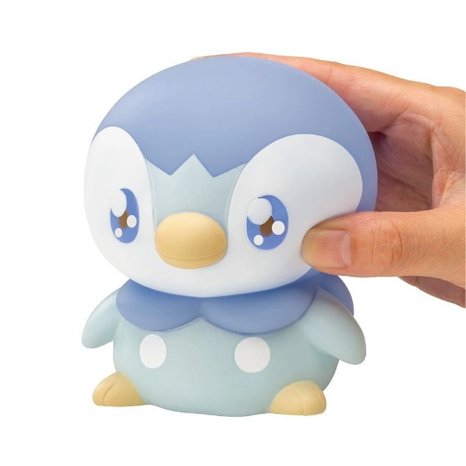  Piplup toy being held, featuring blue and white coloring, large eyes, and a yellow beak.