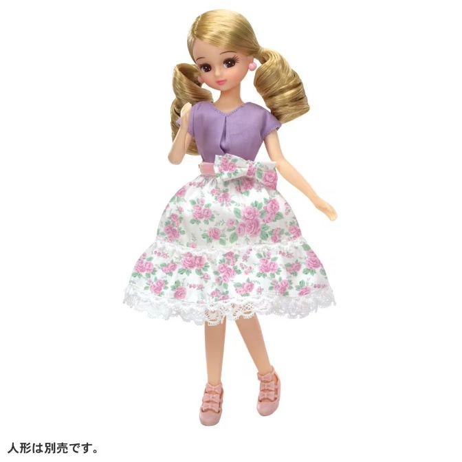  Doll with blonde pigtails, purple top, floral skirt, and pink shoes.