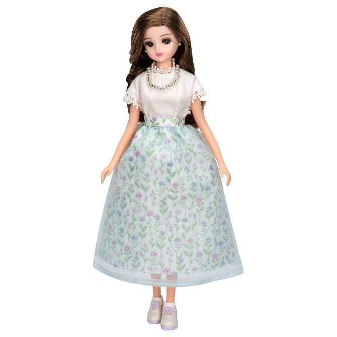  Doll with brown hair, wearing a white top, floral skirt, pearl necklace, and sneakers.