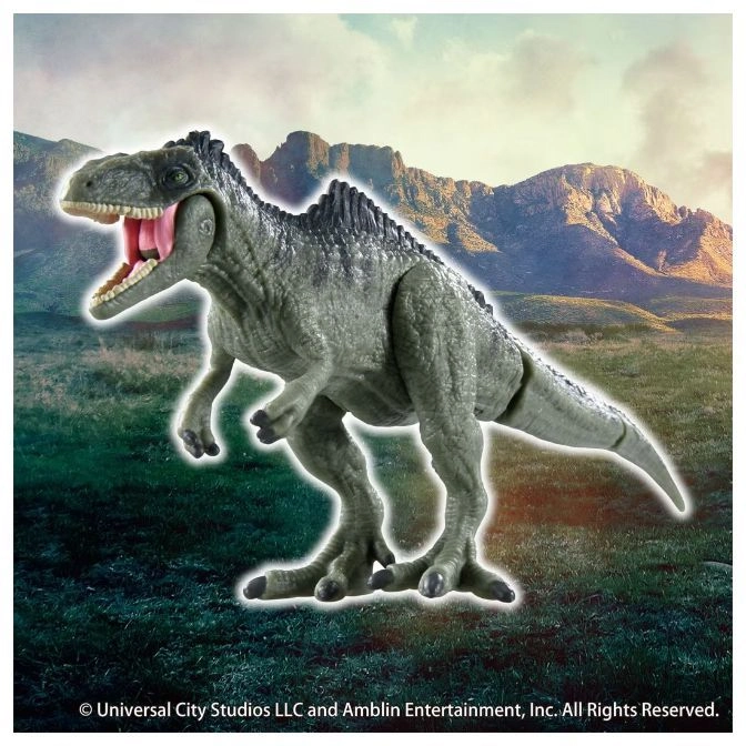  Grey dinosaur toy with open mouth and spiky back standing in a grassy field.