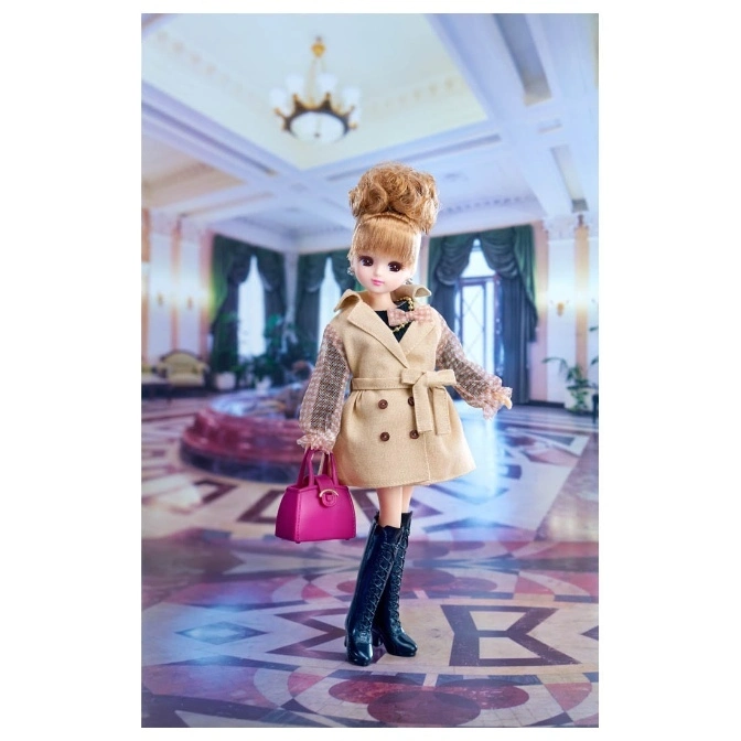  Licca doll in a tan coat, black boots, and pink purse stands in a grand hall.
