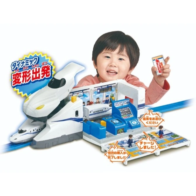  Toy train station with bullet train, ticket machine, and child holding a card.