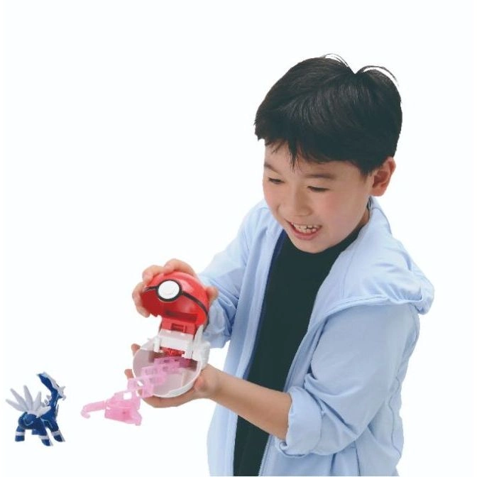  Boy playing with a Pokémon toy set featuring a Poké Ball and a Dialga figure.