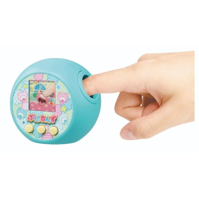 Teal Tamagotchi-like toy with a finger pressing a button, showing a cartoon on the screen.