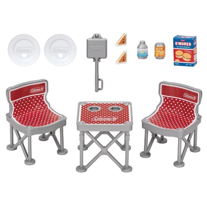 Toy Coleman picnic set with table, chairs, plates, food, and cooking tool.