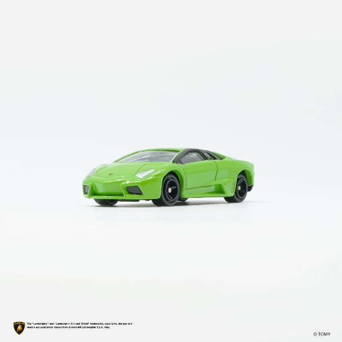  Green toy Lamborghini Reventón with black wheels and roof on a white surface.