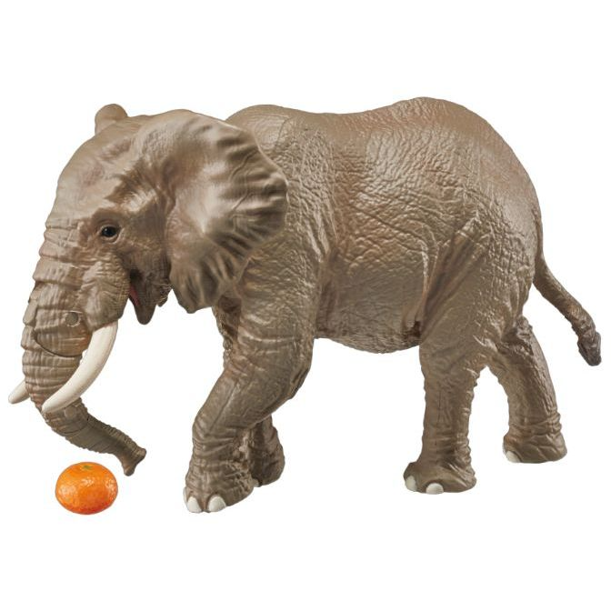 Toy elephant with tusks near a tangerine.
