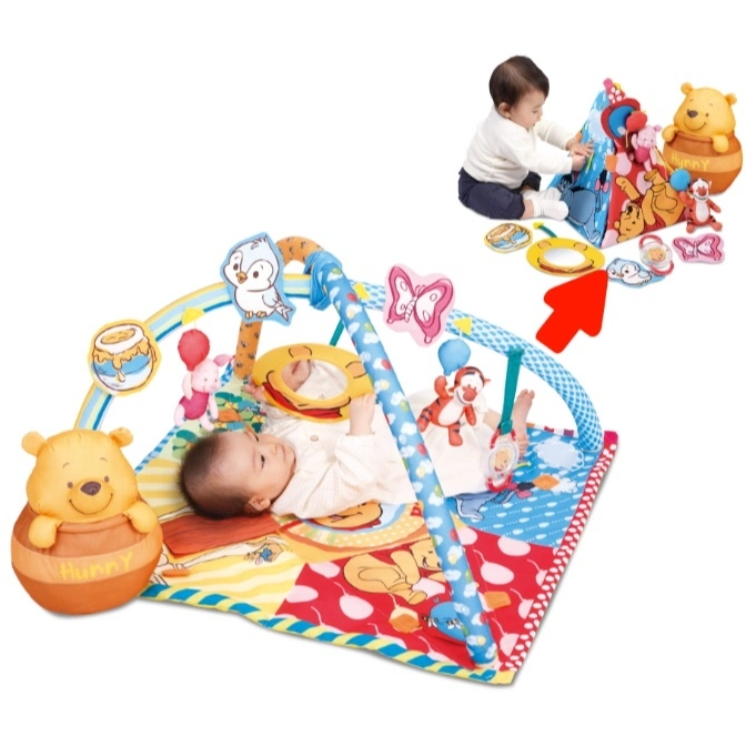  Winnie the Pooh baby gym with hanging toys and a baby lying underneath.