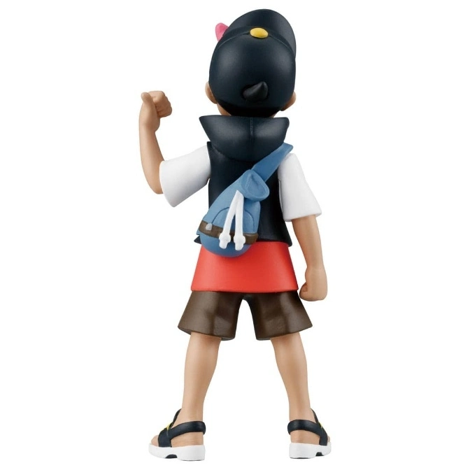  Toy figure of a boy with a backpack, wearing a hat, shorts, and sandals, seen from the back.