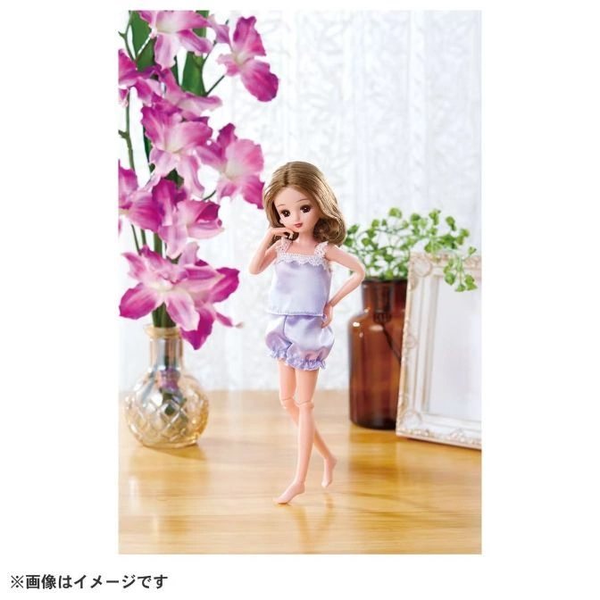  Licca doll in lavender pajamas, standing near flowers and a frame.