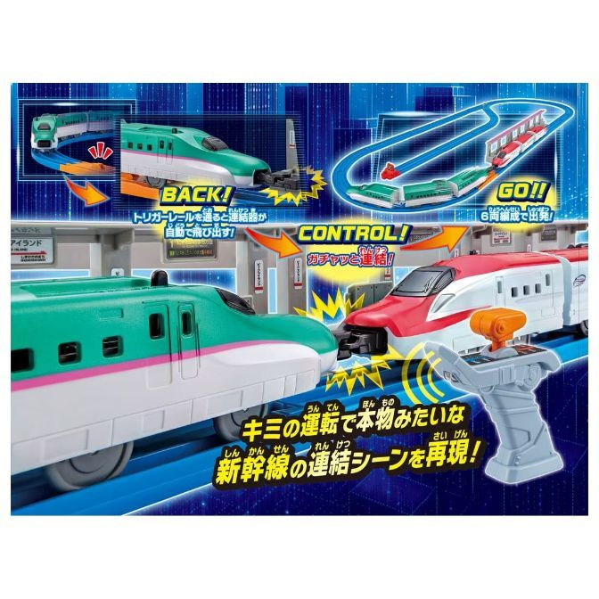 A toy train set featuring two bullet trains, one green and one red, about to connect. The set includes a control panel and a track layout with a trigger rail that automatically deploys the couplers. The packaging highlights the realistic train connection scene.