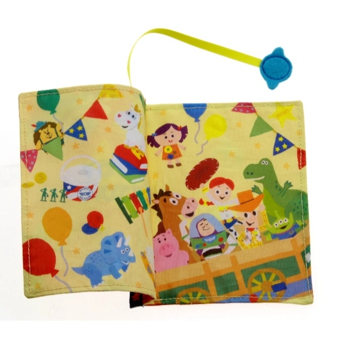  Open cloth book featuring Toy Story characters and colorful illustrations on a yellow background.