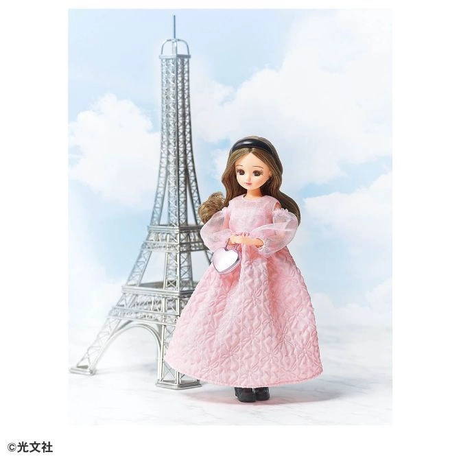 Licca doll in pink dress with Eiffel Tower backdrop, holding heart purse.