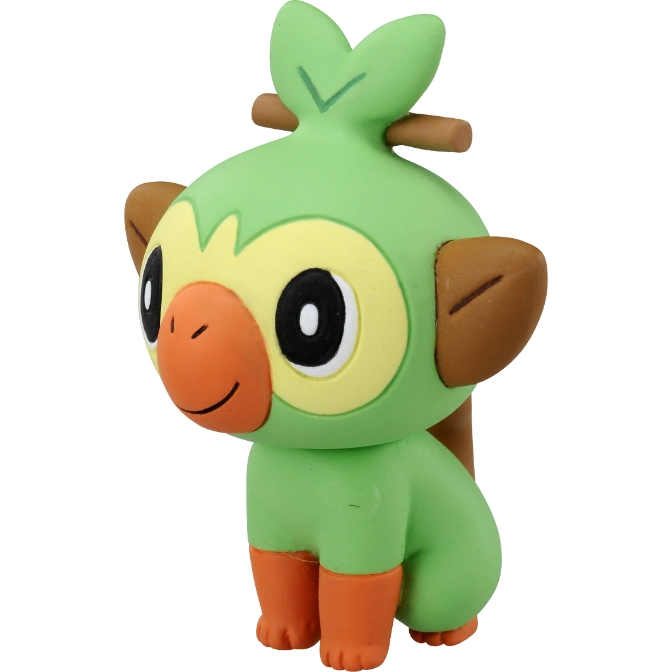 Grookey toy figure with green body, brown ears, orange face and feet, and a stick in its hair.
