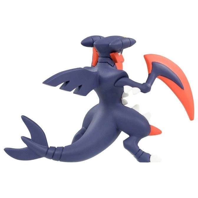  Garchomp toy figure in a dynamic pose, featuring its dark blue body and red blade-like hands.