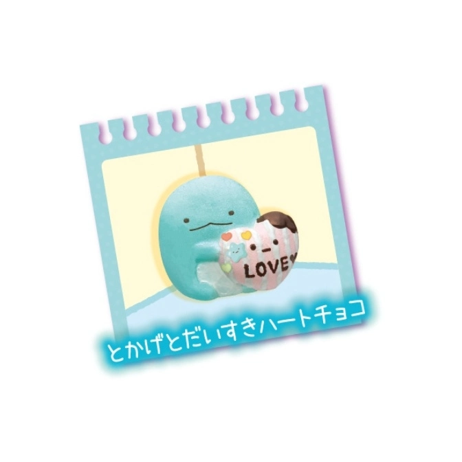  Blue Sumikko Gurashi holding a heart-shaped chocolate with "LOVE" written on it, on a notepad.
