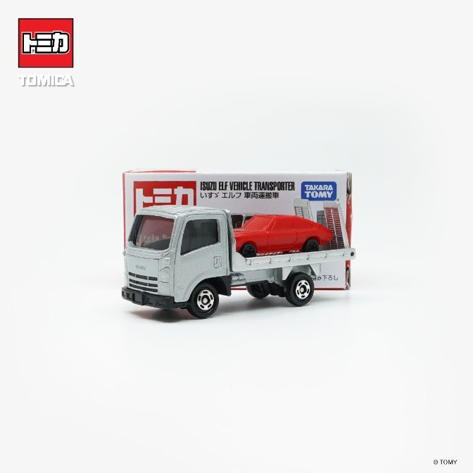 Tomica Isuzu Elf vehicle transporter toy with a red car on its flatbed.