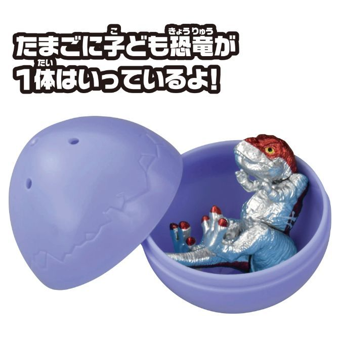  Toy dinosaur hatching from a cracked egg. Red and silver dinosaur figure.