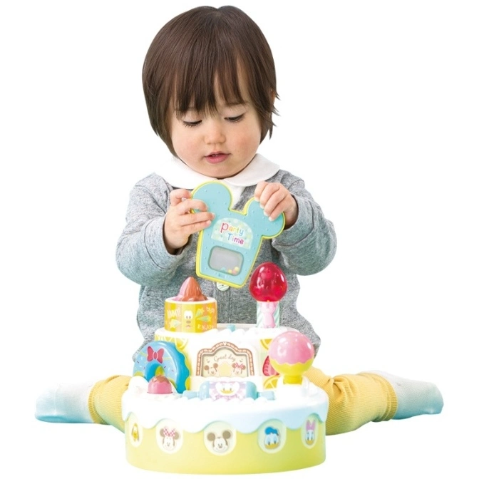  Baby playing with a Disney-themed interactive toy cake with removable pieces.