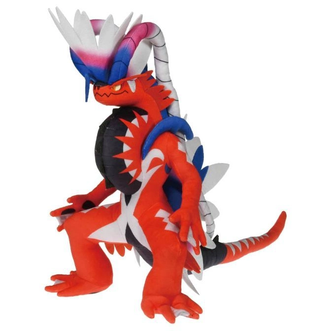 Koraidon plush toy, red with white accents, crouching pose, detailed features.