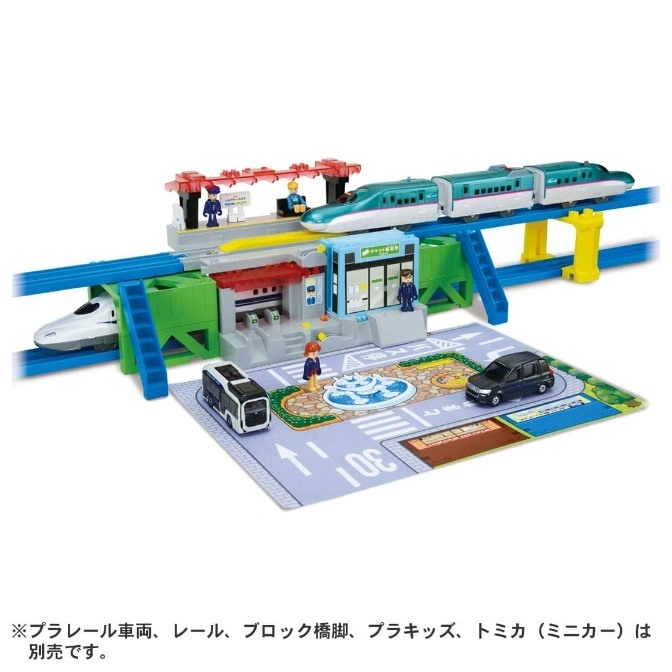 Toy train set with bullet train, station, figures, cars, and playmat.